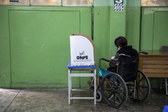 Una persona con discapacidad física que utiliza silla de ruedas se encuentra ejerciendo sufragio en una ánfora de votación de la ONPE.