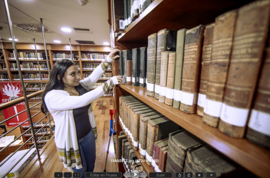 La imagen muestra a una mujer de mediana edad seleccionando un libro.